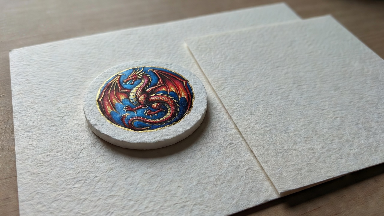 Detailed tabletop photograph showing card paper grain, a painted token and controlled bright edges